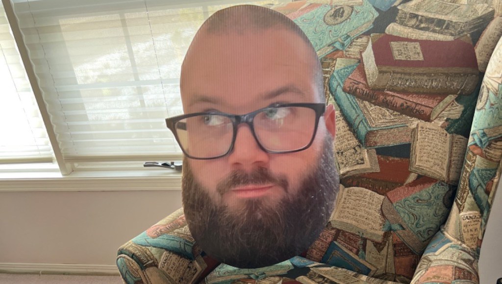 Big head cutout of a man with glasses